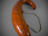 an old wooden walking stick with a handle on a gray surface