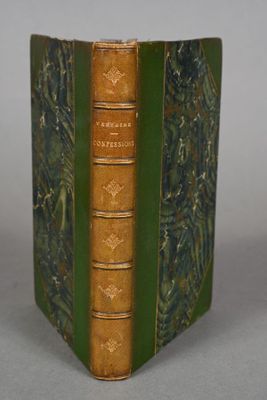 an old book with a green cover sitting on top of a table