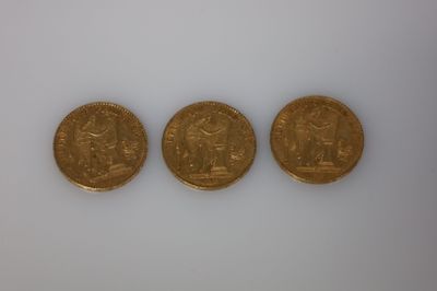 trois types différents de pièces d'or sur une surface blanche