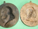 two metal molds of a man and a woman on a green surface