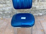 a blue chair that is sitting in front of a stone wall