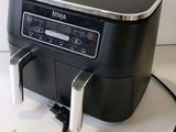 a black and silver coffee maker on a white table