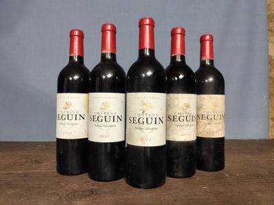 four bottles of wine are lined up on a wooden table
