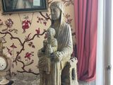 a statue of a woman sitting on a chair next to a clock