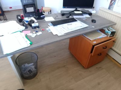 un bureau sur lequel se trouvent un ordinateur, un clavier, une souris et des papiers