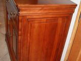 a wooden cabinet in the corner of a room