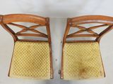 two wooden chairs with yellow upholstered cushions on them
