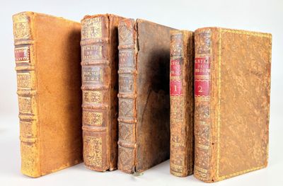 plusieurs vieux livres sont alignés sur une surface blanche