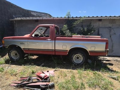 a red and white truck that is parked in the grass