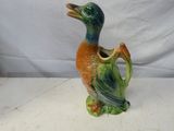un petit canard en céramique posé sur une table