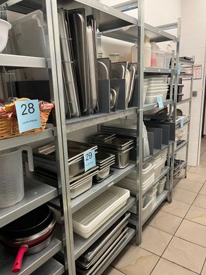 many pots and pans on the shelves in the kitchen