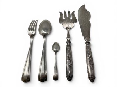 four forks, spoons, and a knife on a white surface