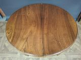 an image of a round wooden table with two leaves on it