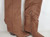 une paire de bottes marron posée sur un sol blanc