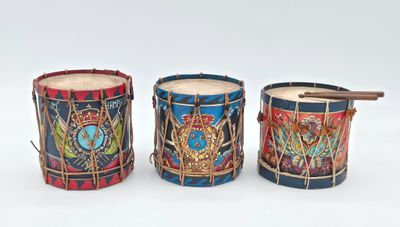 three drums are lined up in a row on a white surface
