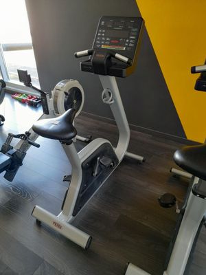 un vélo d'appartement dans une salle de sport aux murs jaunes