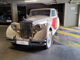 a old car parked in a parking garage next to other cars