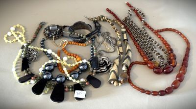 many different necklaces and bracelets laid out on a table