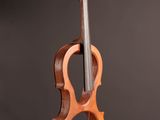 un violon en bois posé sur un pupitre, sur fond noir