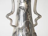 a silver vase that is sitting on a table