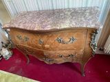 a wooden chest of drawers with a marble top