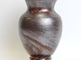 a brown vase sitting on top of a white table