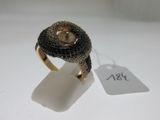 une image représentant une bague en or sertie d'une pierre marron