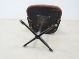 a black chair with four crossed legs and a brown bag