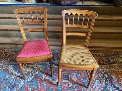 two wooden chairs sitting next to each other on a rug