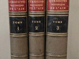 trois livres sont empilés sur une table
