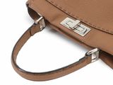 tan leather handbag on a white background with a metal clasp