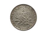une vieille pièce de monnaie sur laquelle figure une branche, sur fond blanc