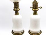 une paire de lampes en verre blanc avec des fixations en laiton et une ampoule blanche