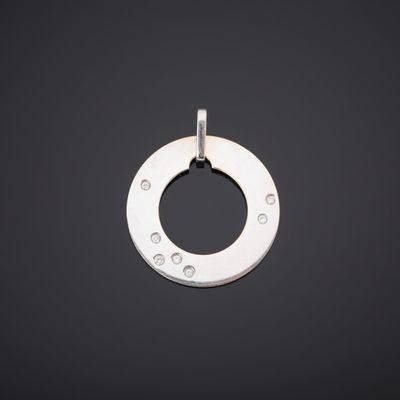 un pendentif plaqué argent présentant un motif circulaire sur fond noir