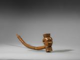 une image représentant une pipe en bois sur laquelle est gravé le visage d'un homme