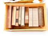books in a wooden box on top of a white surface