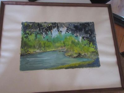 une photo d'un tableau représentant une rivière, dans un cadre en bois