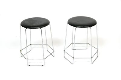 two black stools sitting next to each other on a white surface