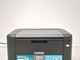 a black printer sitting on top of a table next to a white wall