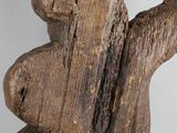 a wooden sculpture of a teddy bear holding a piece of wood