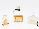 trois flacons de parfum posés l'un à côté de l'autre sur une surface blanche