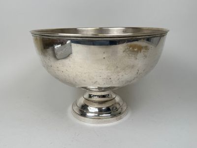 un bol en argent posé sur une table blanche