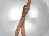 a white bowl with a brown leather strap on it
