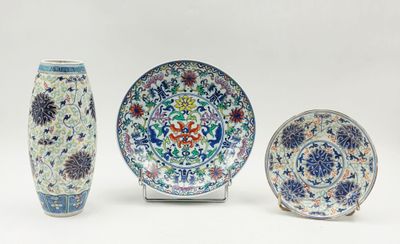Trois pièces de poterie chinoise sont exposées sur un fond blanc