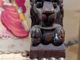 a lion head on the back of a chair in front of a wallpapered wall