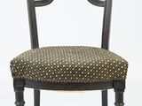 une chaise noire dont l'assise et le dossier sont à motifs