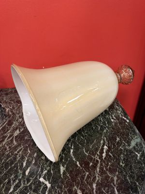 un vase blanc posé sur une table en marbre, avec un mur rouge en arrière-plan