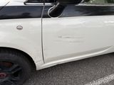 a small white car parked in a parking lot