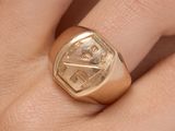 quelqu'un tient une bague en or sur laquelle est gravée la photo d'un homme
