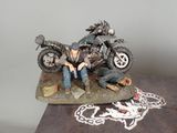 a figurine of a man sitting on a motorcycle